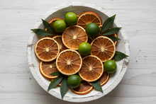Load image into Gallery viewer, dried oranges key lime and patchouli in a wooded aged white bowl
